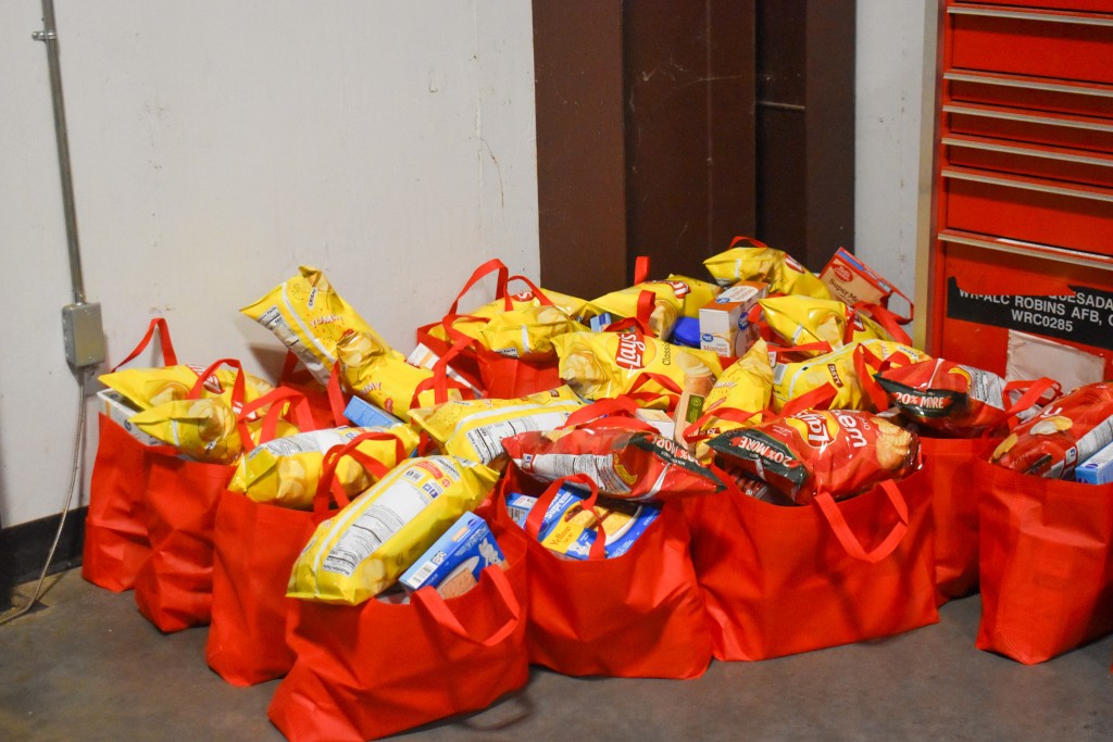 Red bags filled with food on the ground.