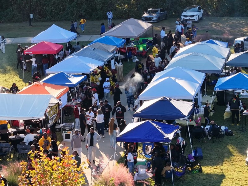 An overhead photo of people walking. Blue tents are set up around the area.
