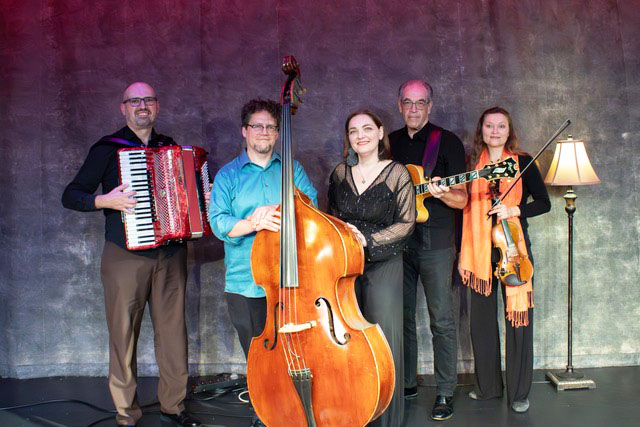A group of people smiling and holding their instruments.