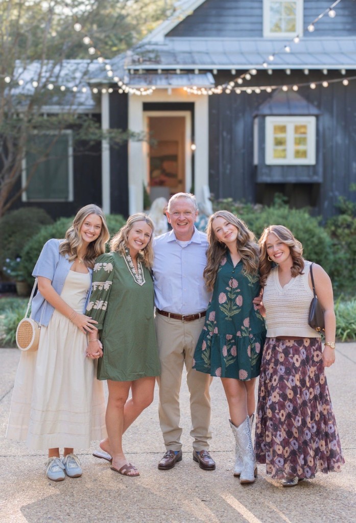 A family of five smiling.