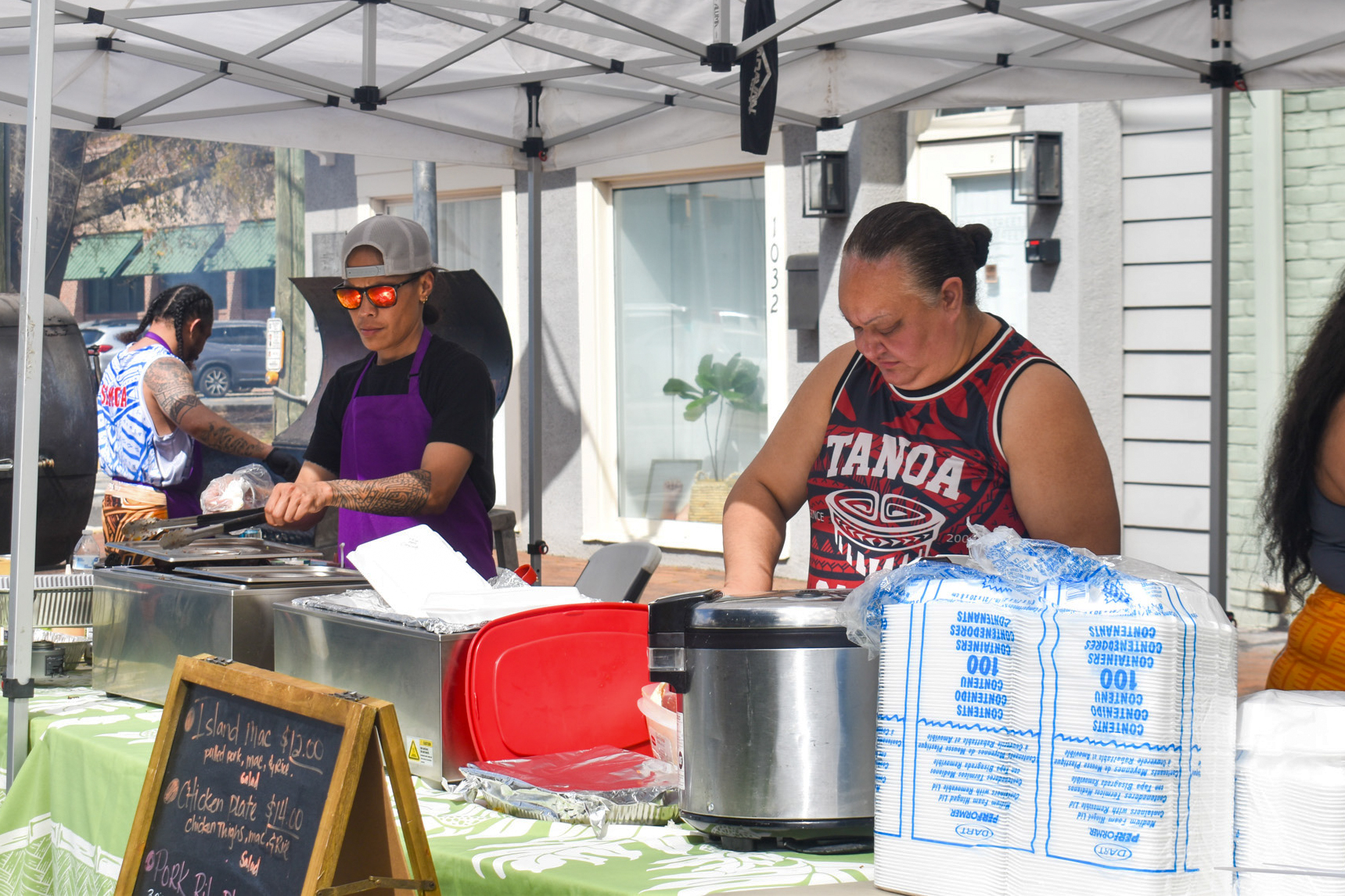 A man and a woman behind a table cooking.