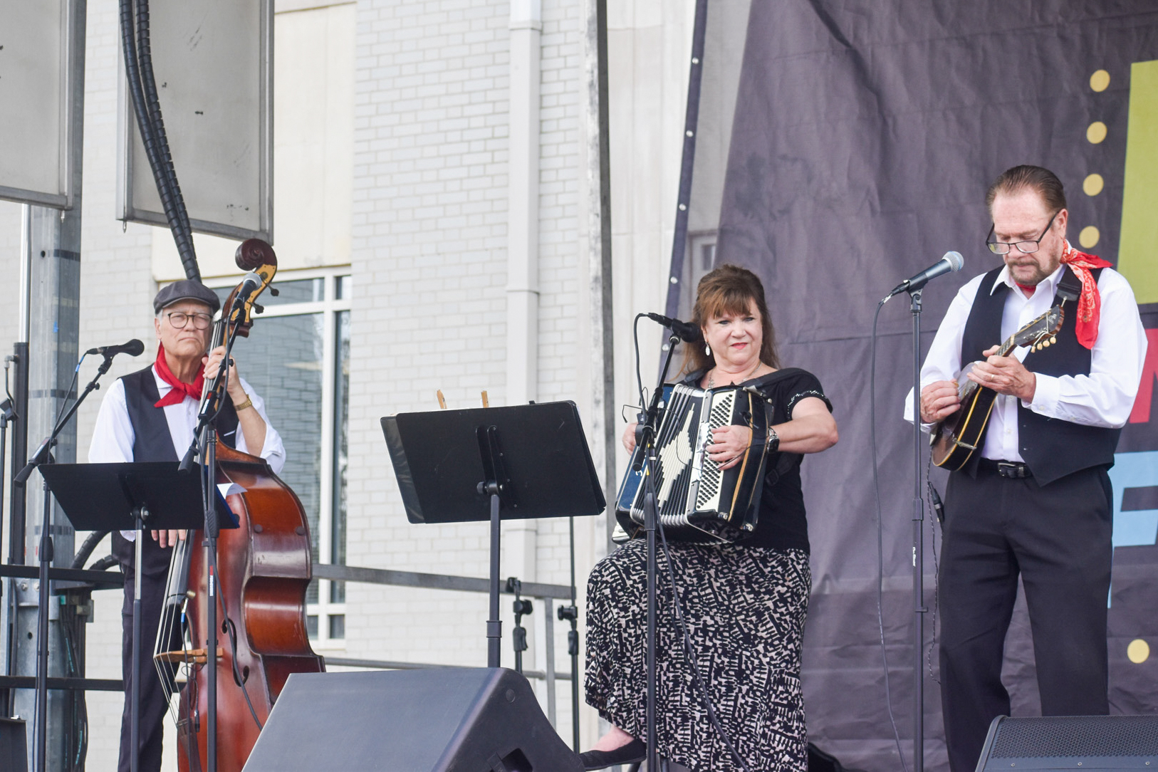 Two men and a woman performing on stage.