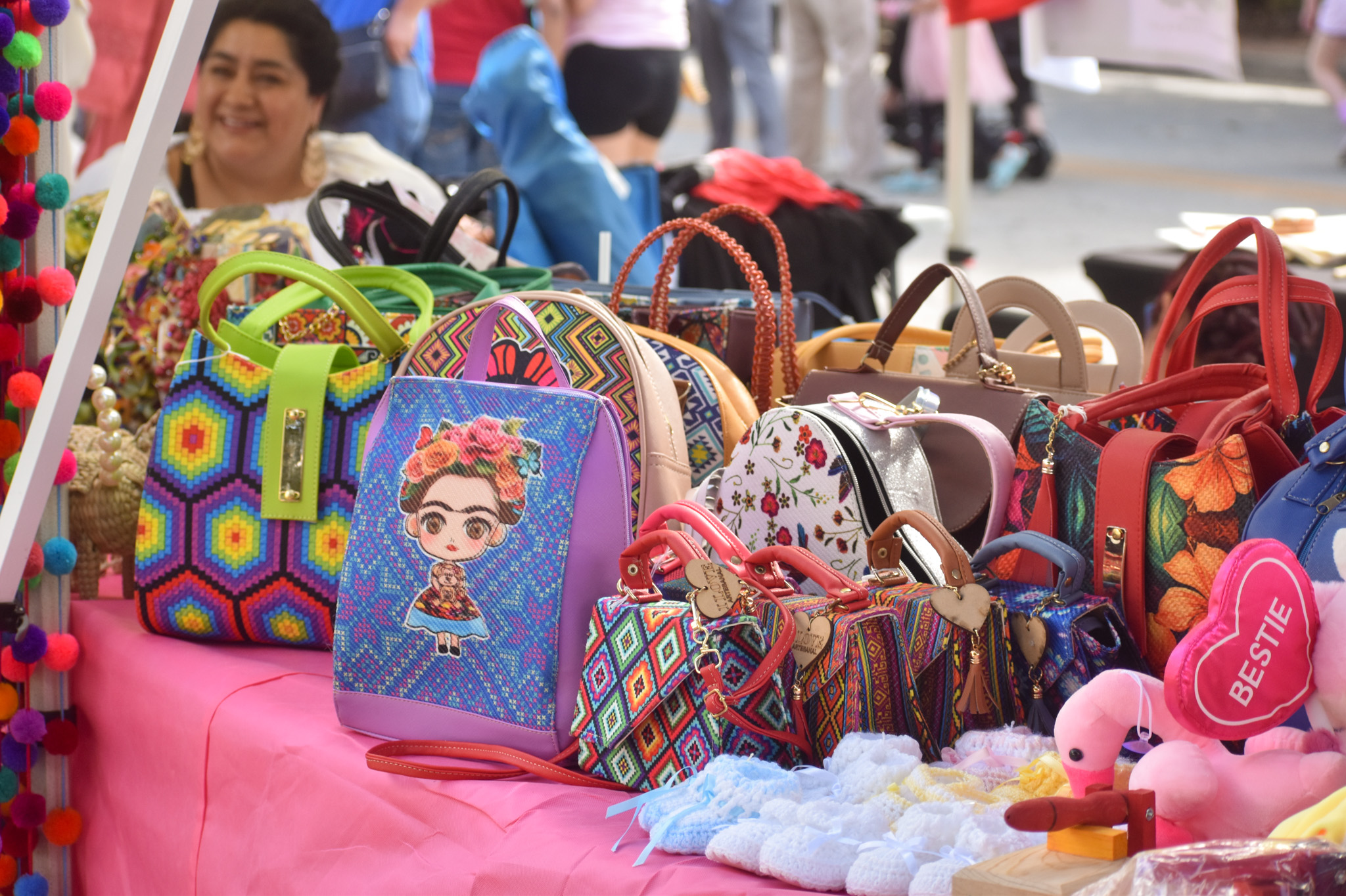 Purses on a table. The table is covered in a pink cloth.