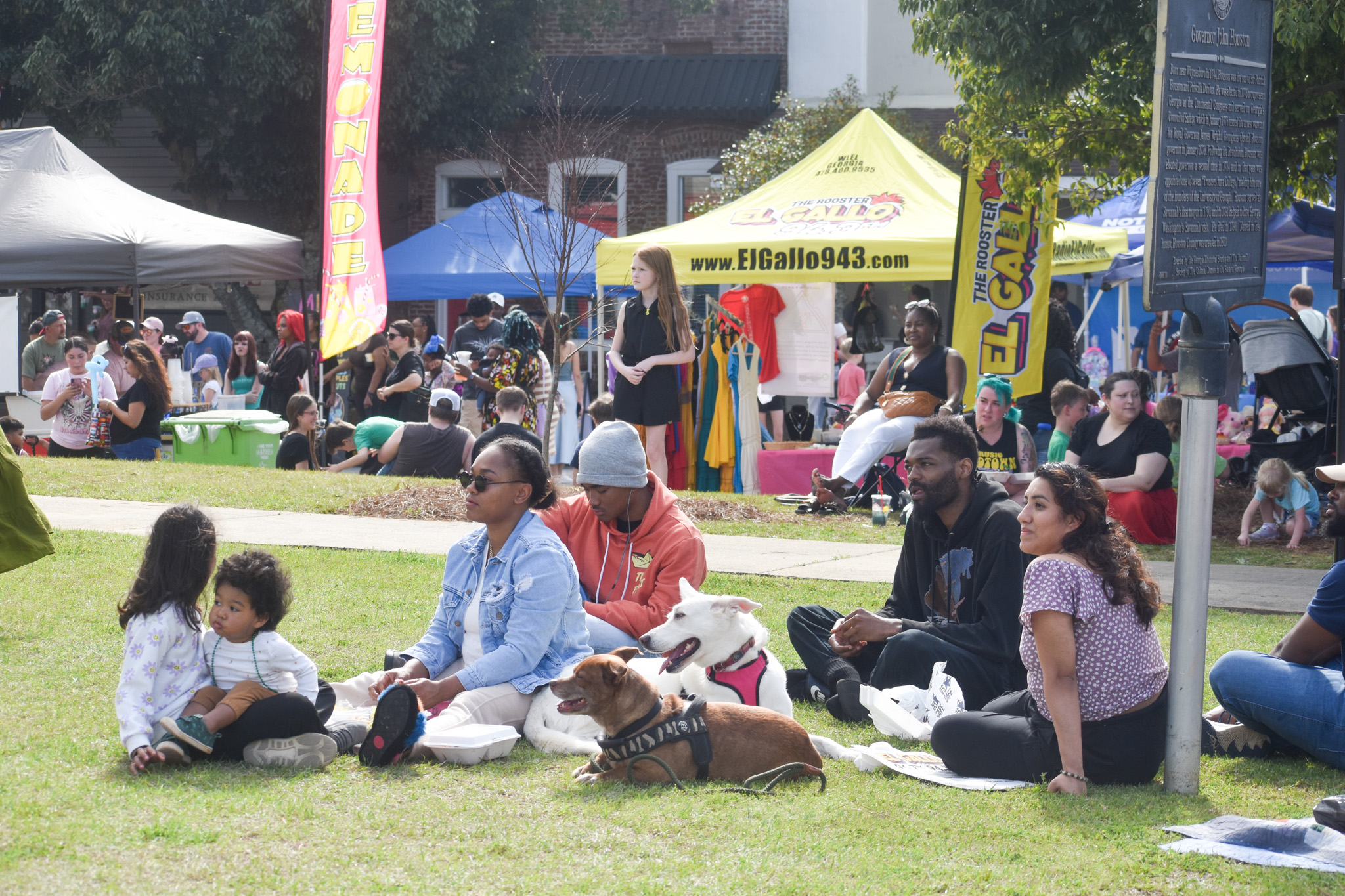 A group of people sitting on the grass.