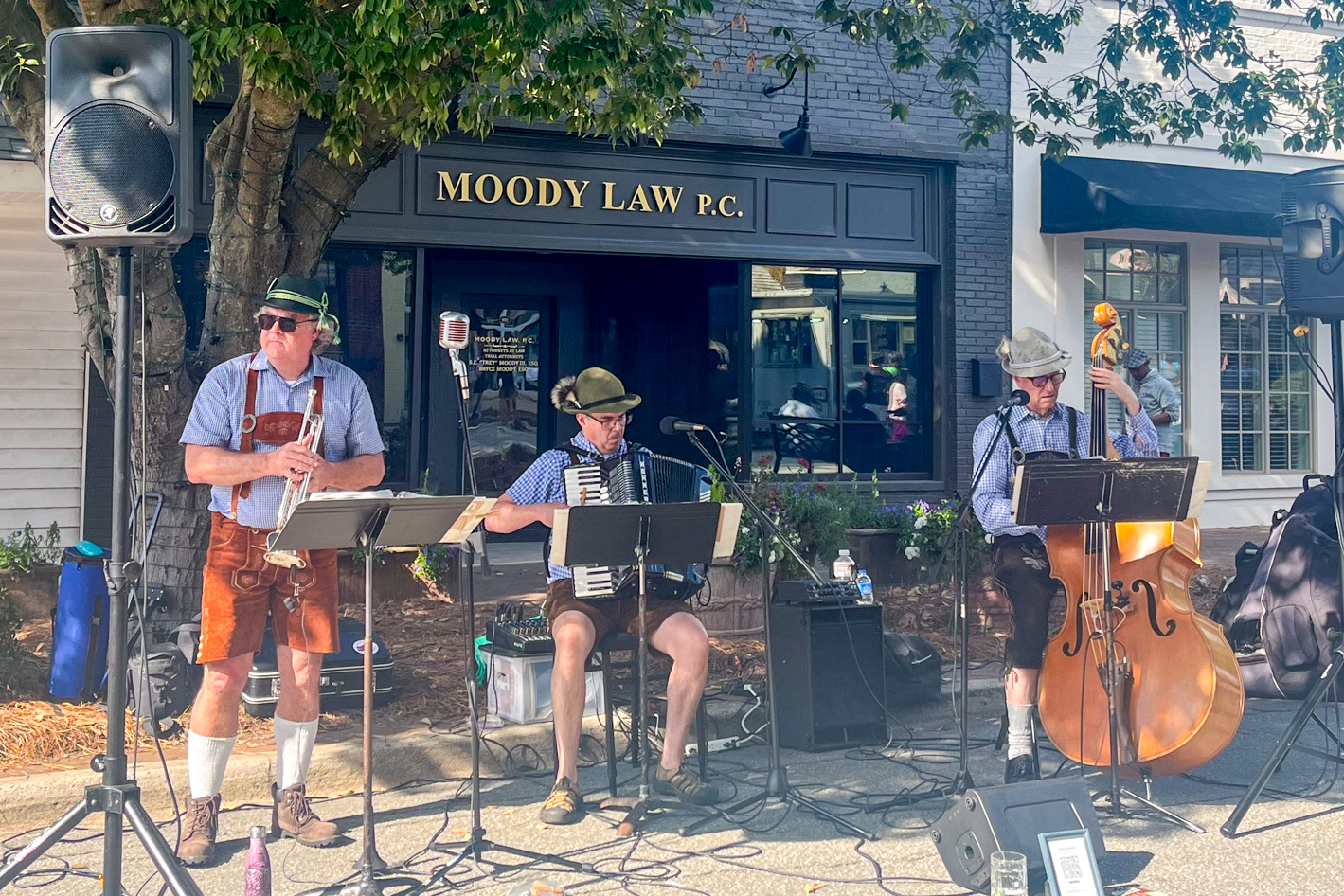 Three men with instruments performing on the street.