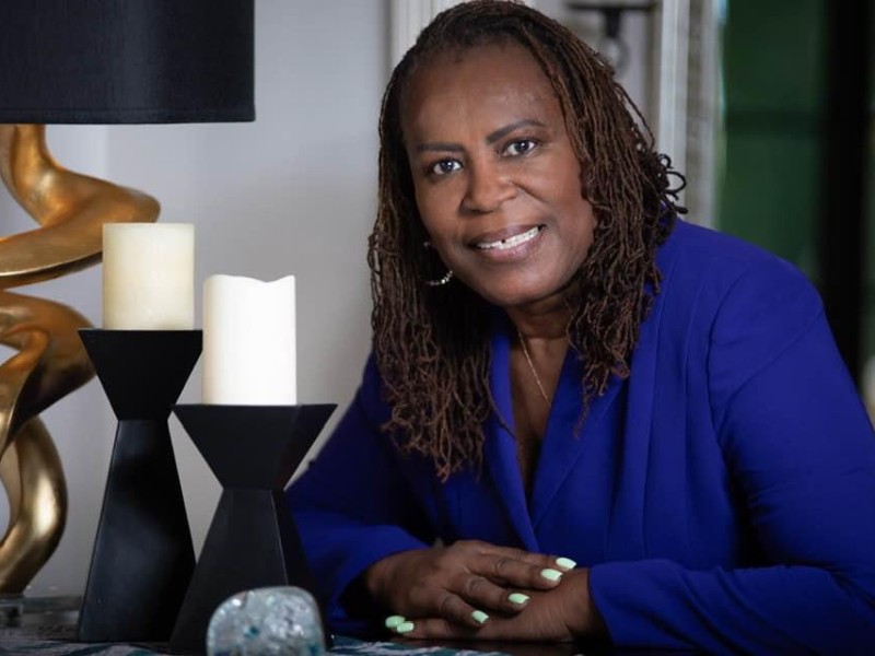 A woman in a blue shirt smiling.