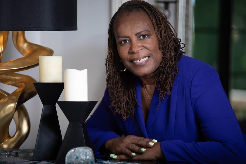 A woman in a blue shirt smiling.