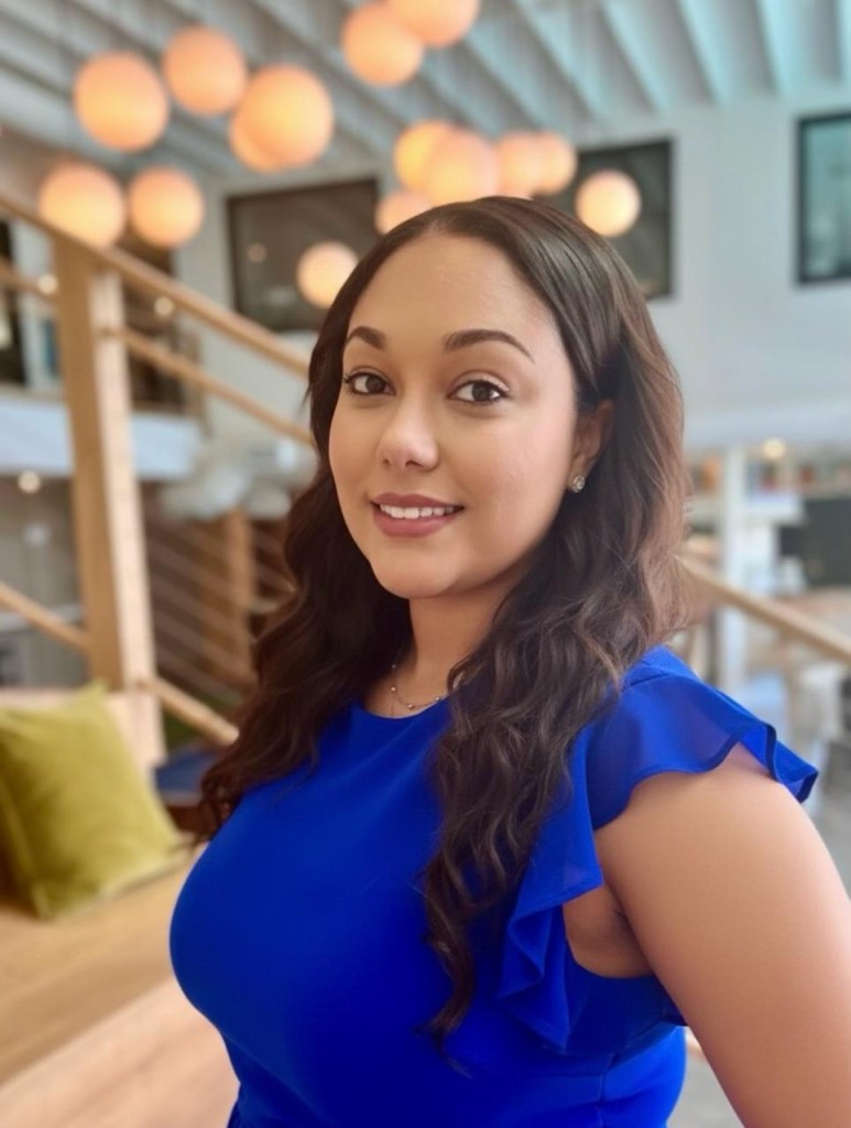 A woman in a blue shirt smiling. 
