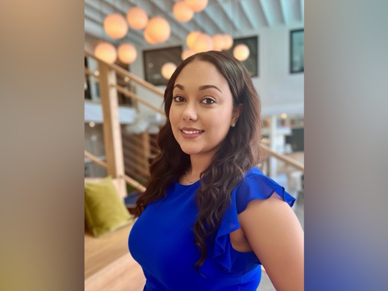 A woman in a blue shirt smiling.