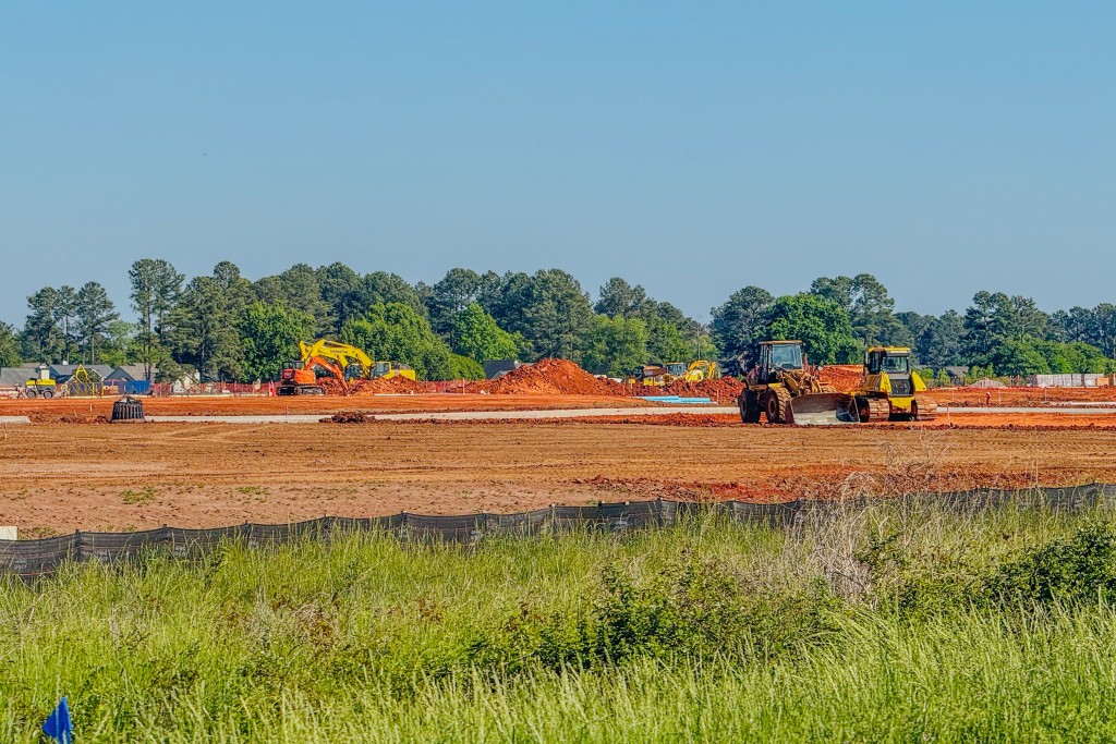 A field with dirt and tractors. 