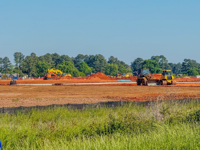 A field with dirt and tractors.