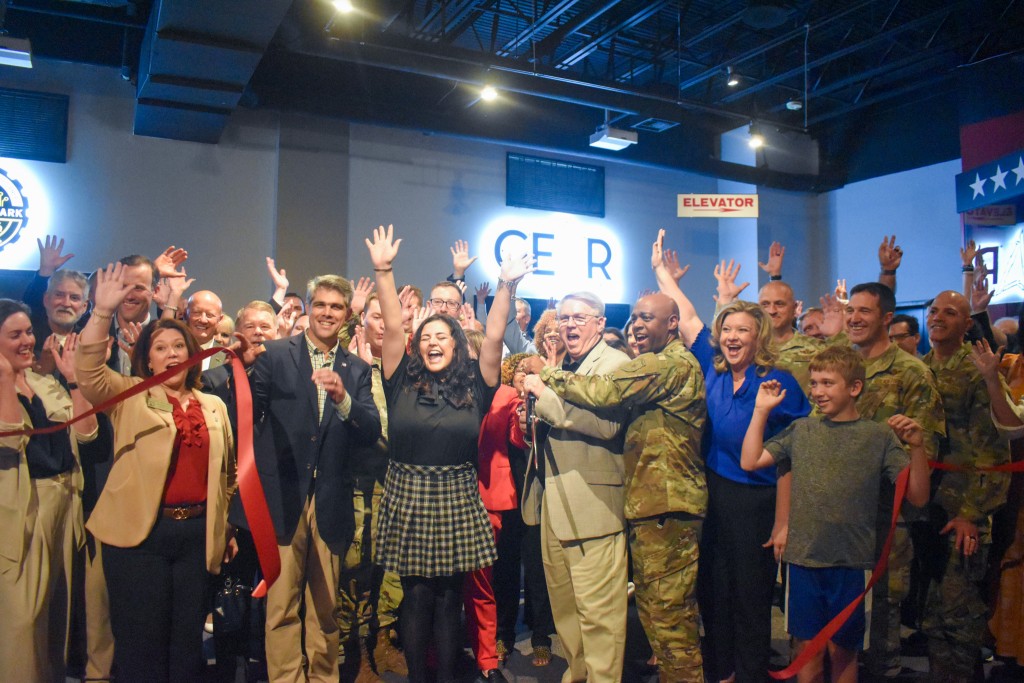 A group of people holding their hands up and smiling.