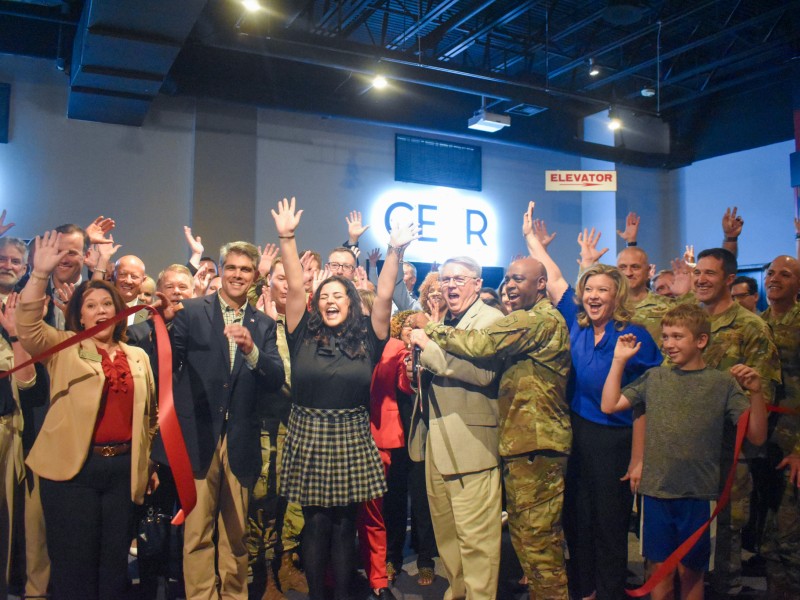 A group of people holding their hands up and smiling.