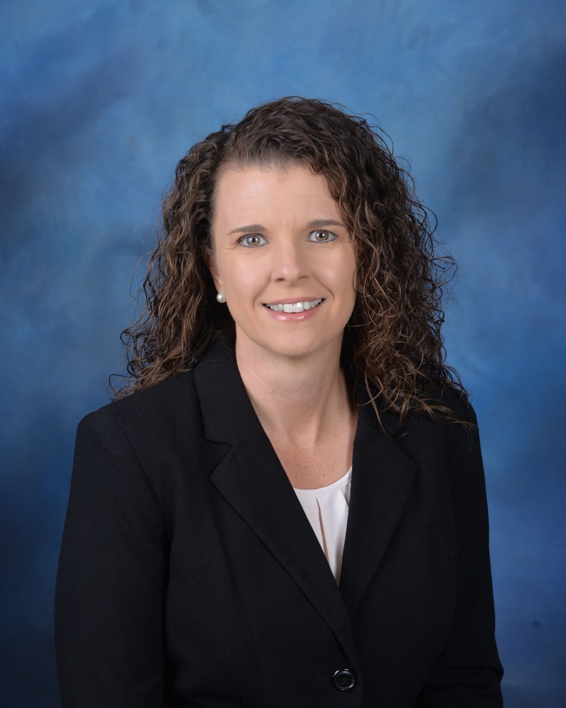 A woman in a black suit smiling.