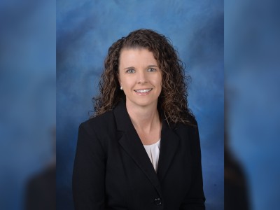 A woman in a black suit smiling.