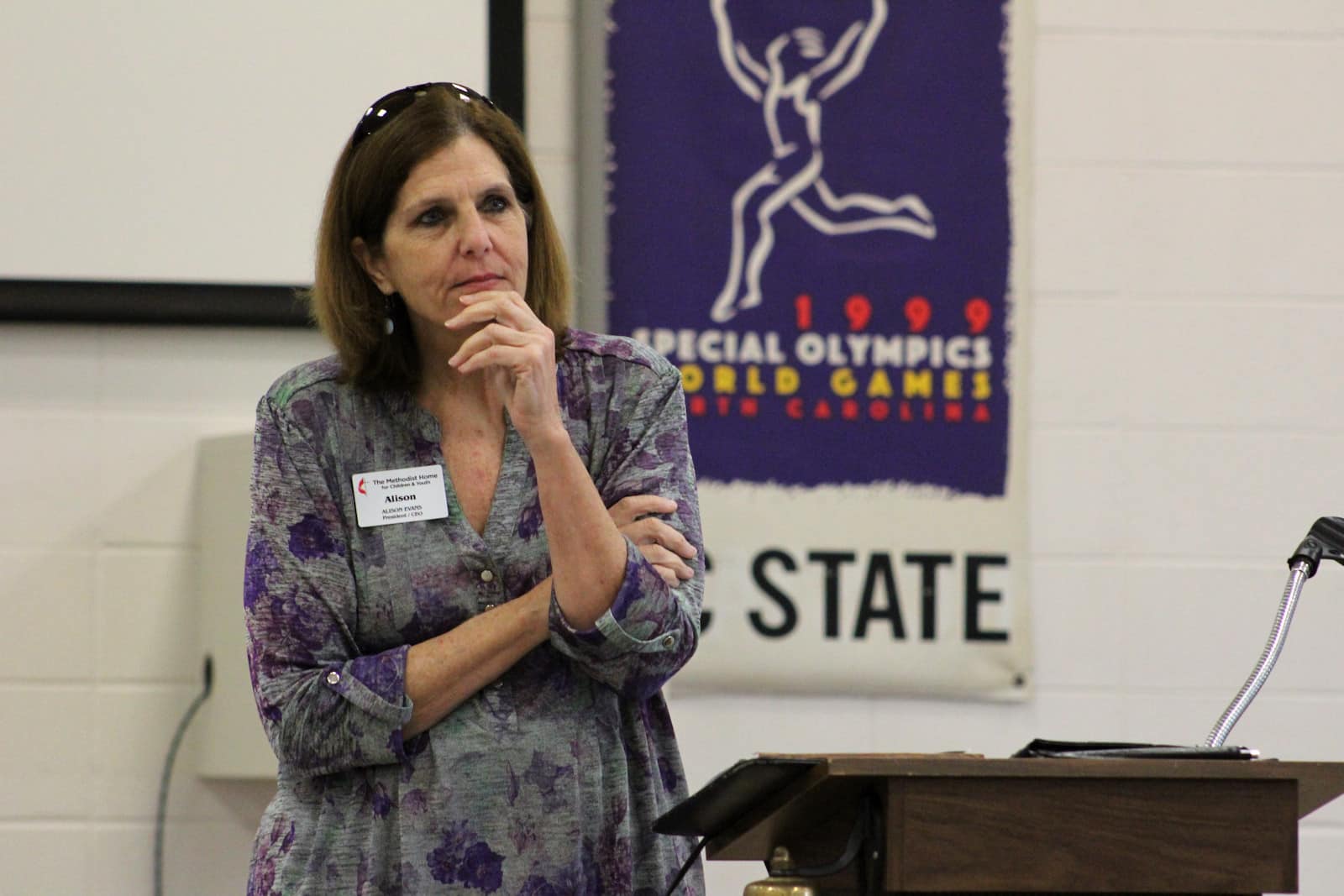 A older white woman with shoulder length brown hair listens.