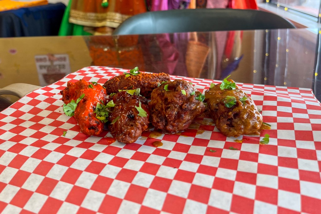 Chicken wings laid on a red and white checkered paper.