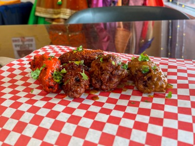 Chicken wings laid on a red and white checkered paper.