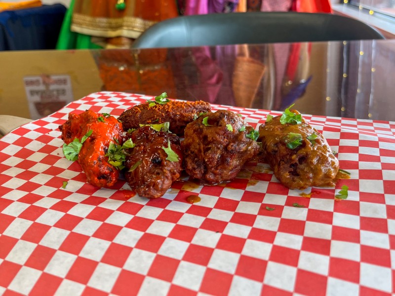 Chicken wings laid on a red and white checkered paper.