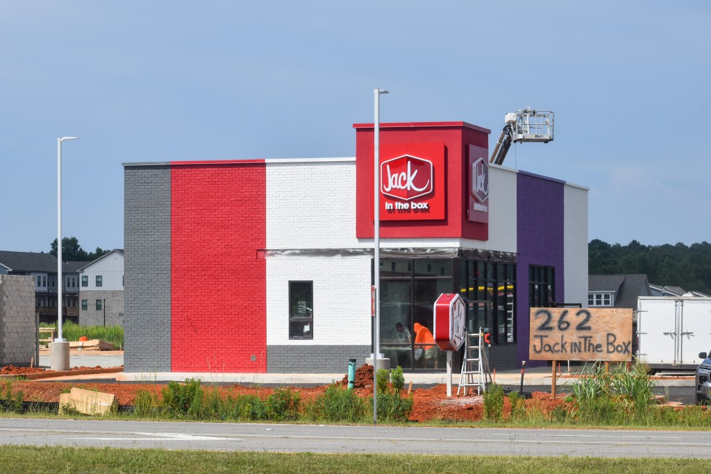 A red and purple building under construction.
