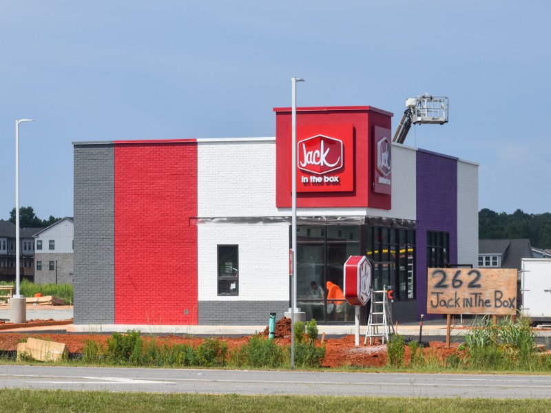 A red and purple building under construction.