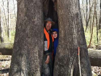An older man and a boy inside a tree.