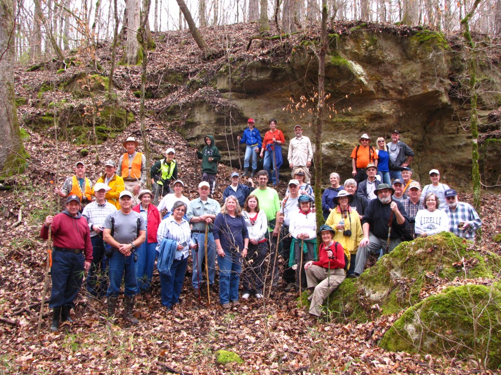 A group of people standing in a forest. 