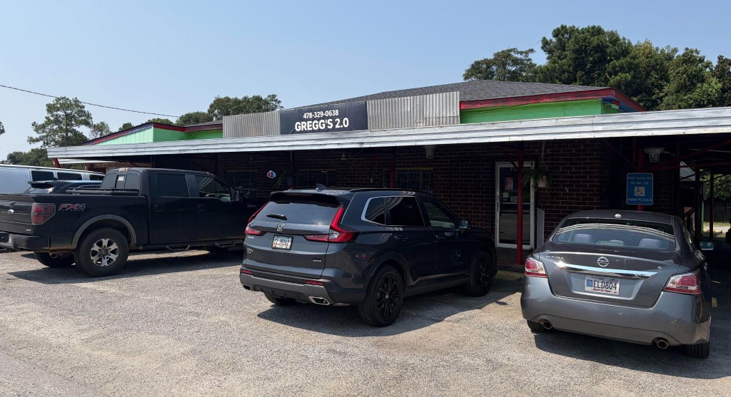 Vehicles parked outside Gregg's Mexican, a tex-mex restaurant in warner robins. The restaurant's sign has an incorrect phone number and former name.