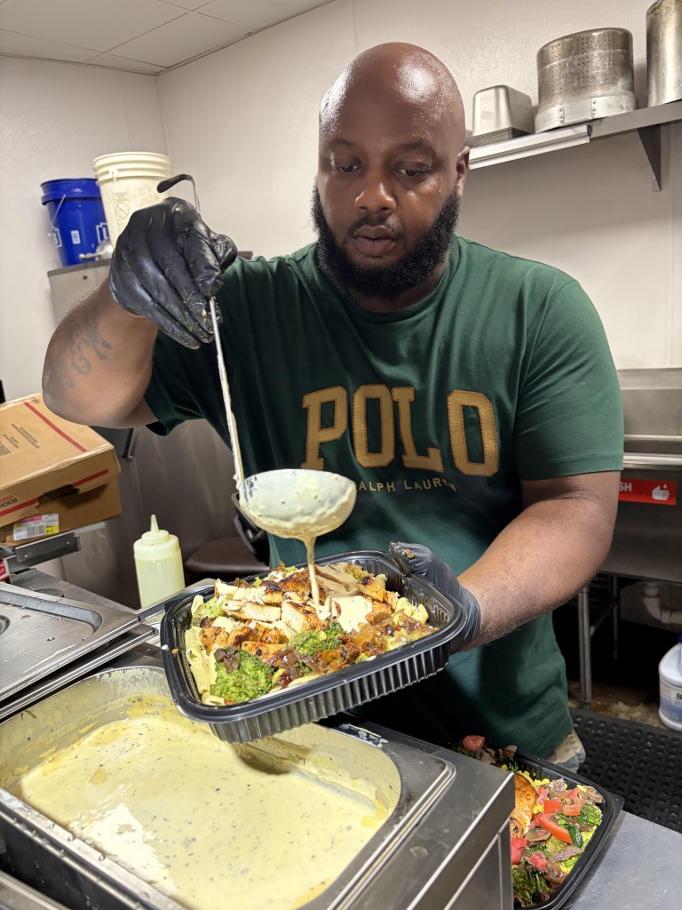 Taste Good Restaurant owner uses a ladle to pour sauces over specialty dish at his restaurant.
