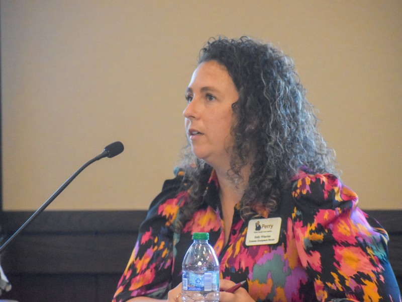 A woman in a colorful dress speaking into a microphone.