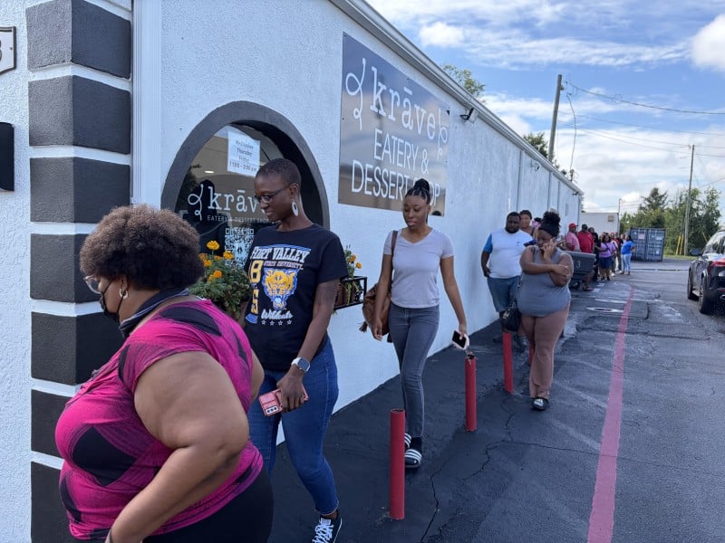 Restaurant customers line the side of the building all the way to the back parking lot. The line started forming about 15 minutes ahead of the regular 11 a.m. opening.