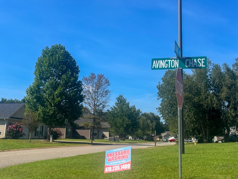A street sign and house in the background.