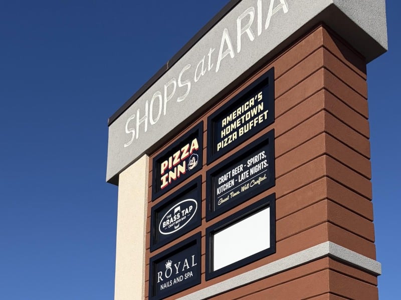 The top of the sign has the shopping center's sign in white over gray with the spaces for tenants in black with names in either yell or white. One space is blank and that's for the newest tenant, Bubbakoo's Burritos.